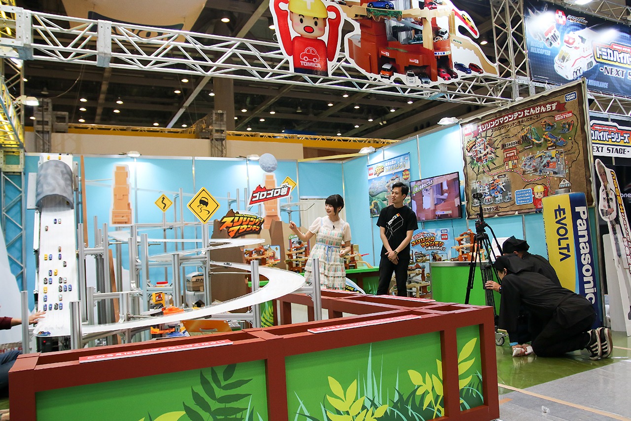 全長20メートルの巨大コースが設置されたトミカコーナーを紹介する上坂すみれ。