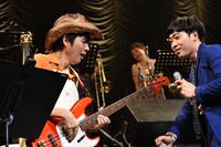 鹿島達也（左）のベースプレイを煽る堂島孝平（右）。