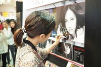 自身のパネルにサインを書き入れる前田敦子。（写真提供：キングレコード）