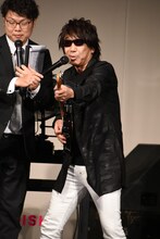 エアギターのテクニック「木根垂直」を披露する木根尚登。