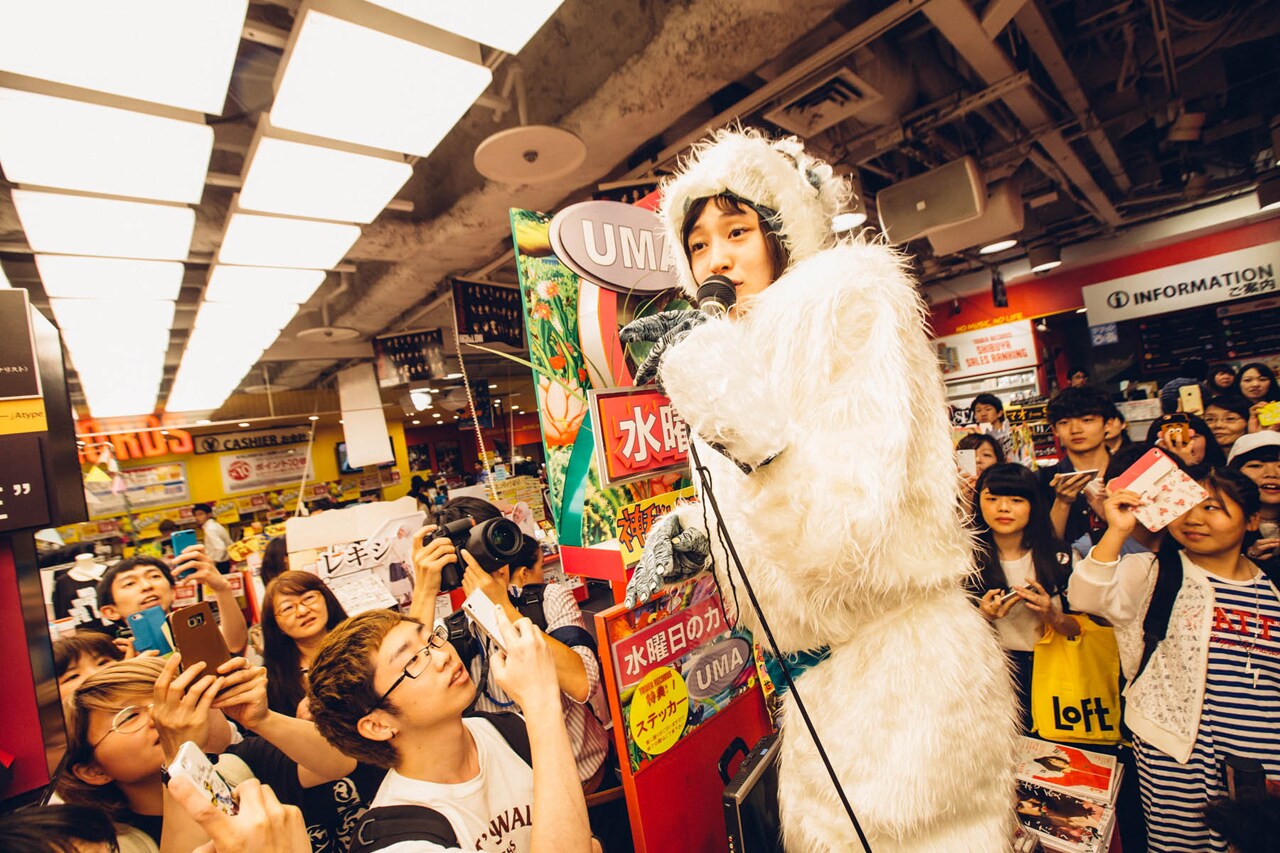 雪男に扮し、東京・タワーレコード渋谷店で歌うコムアイ。