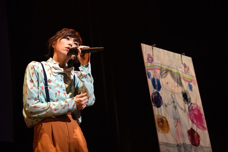 父の似顔絵をそばに置いて「カブトムシ」を歌う安本彩花。