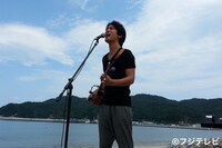 大槌町の吉里吉里海岸で「海の声」を歌う桐谷健太。