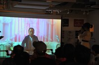 マキタスポーツから届いたVTRを上映中のステージ。