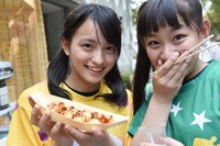 たこ焼きを手に微笑む清井咲希（左）とかつおぶしのみを頬張る根岸可蓮（右）。