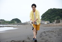 砂浜に大きく「8号車」と書くユースケ。