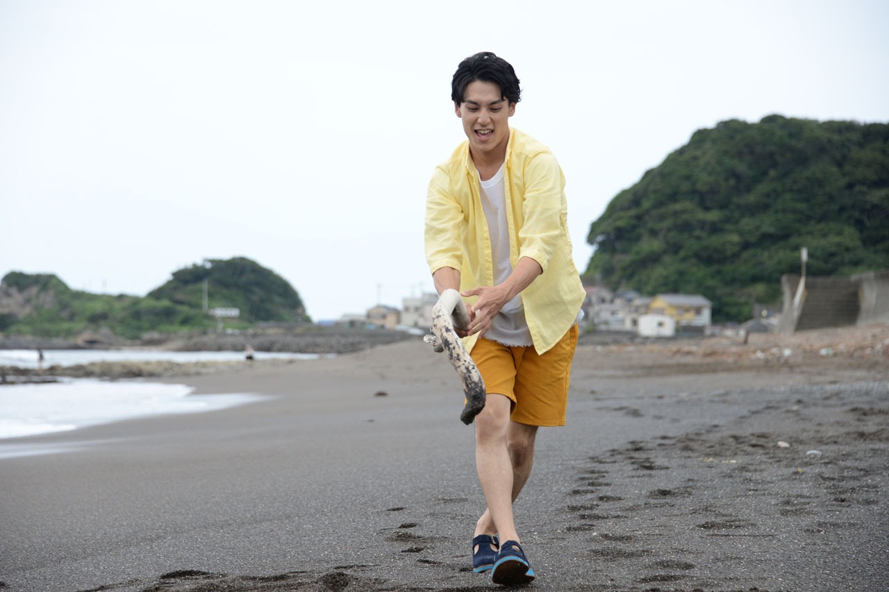 砂浜に大きく「8号車」と書くユースケ。