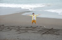 砂浜に大きく「8号車」と書いたユースケ。