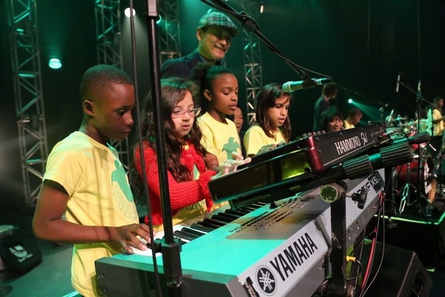 Fabela Brassの子供たちと交流する沖祐市（奥）。（写真提供：Sony Music Brazil）