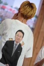 背中の三宅アナを8号車に見せるカイ。