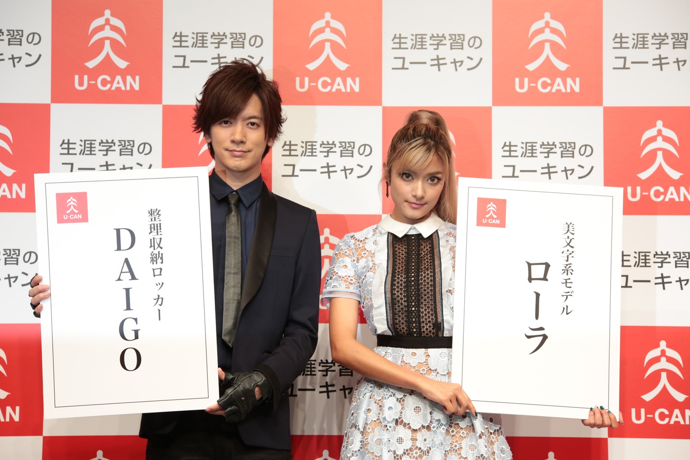 新しい肩書きが書かれた名刺を披露するDAIGO、ローラ。