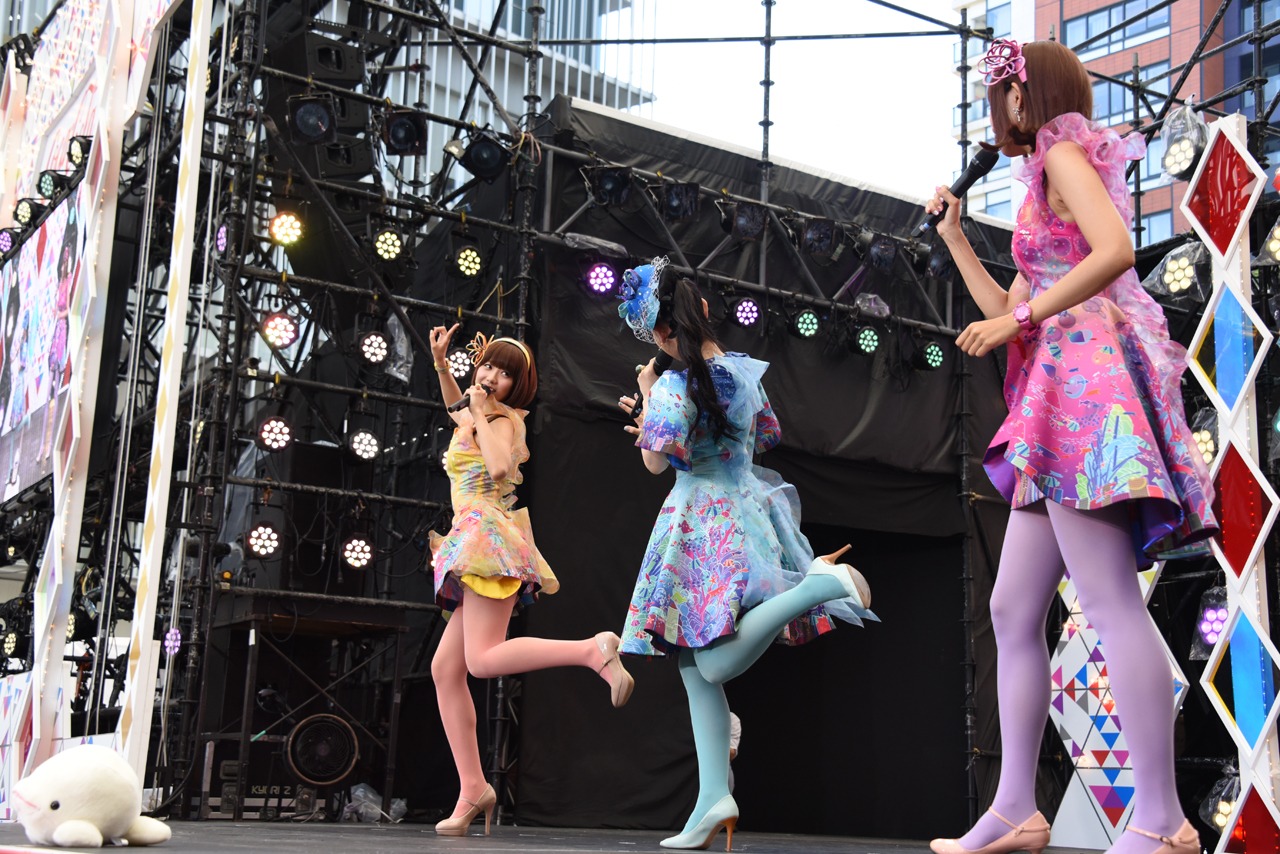 篠原ともえのヒット曲「クルクルミラクル」や「ウルトラリラックス」をジェスチャーで表現するレナ（左）と、正確な動きを指導する篠原本人（中央）。