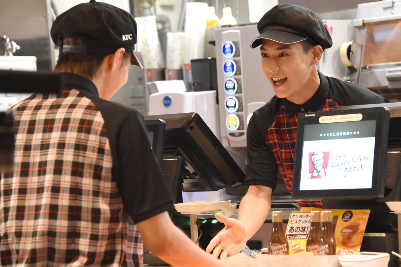 タカシ（左）をお客様役に、サービスの練習をするユースケ（右）。