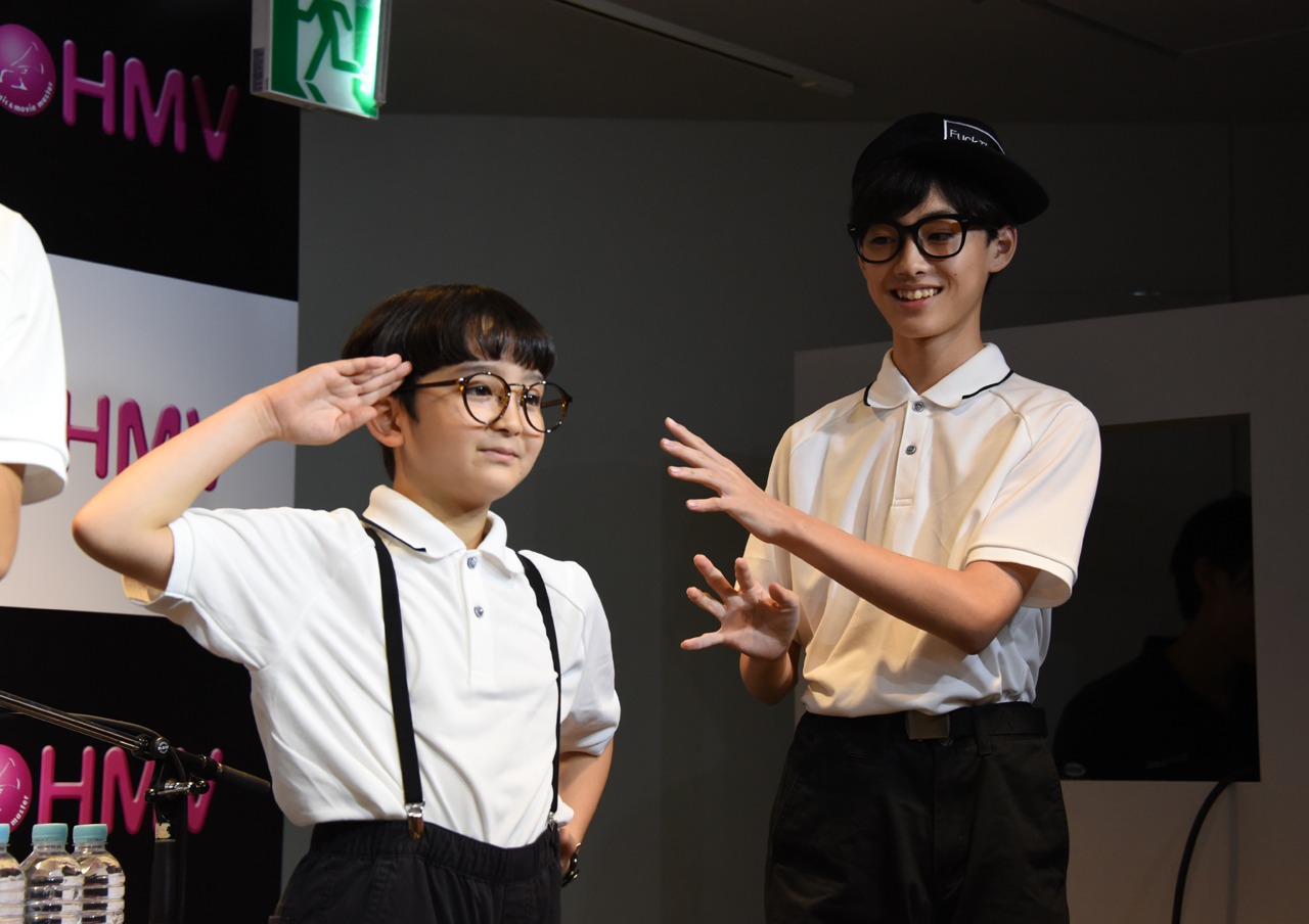 敬礼するミロ（DJ）と手をヒラヒラさせるリュウト（MC）。