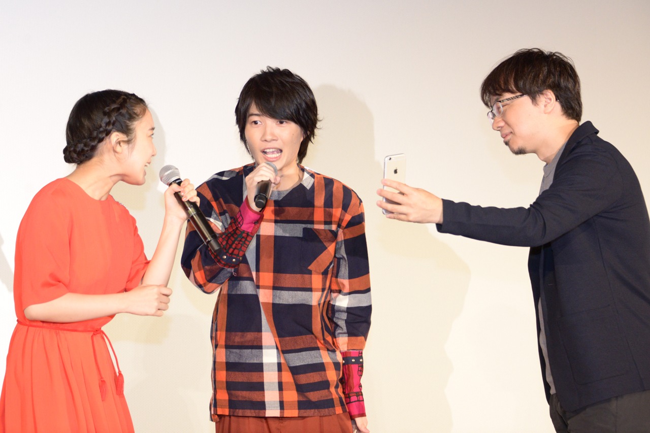 新海誠のスマートフォンでセリフを確認し、劇中のシーンを再現する上白石萌音と神木隆之介。