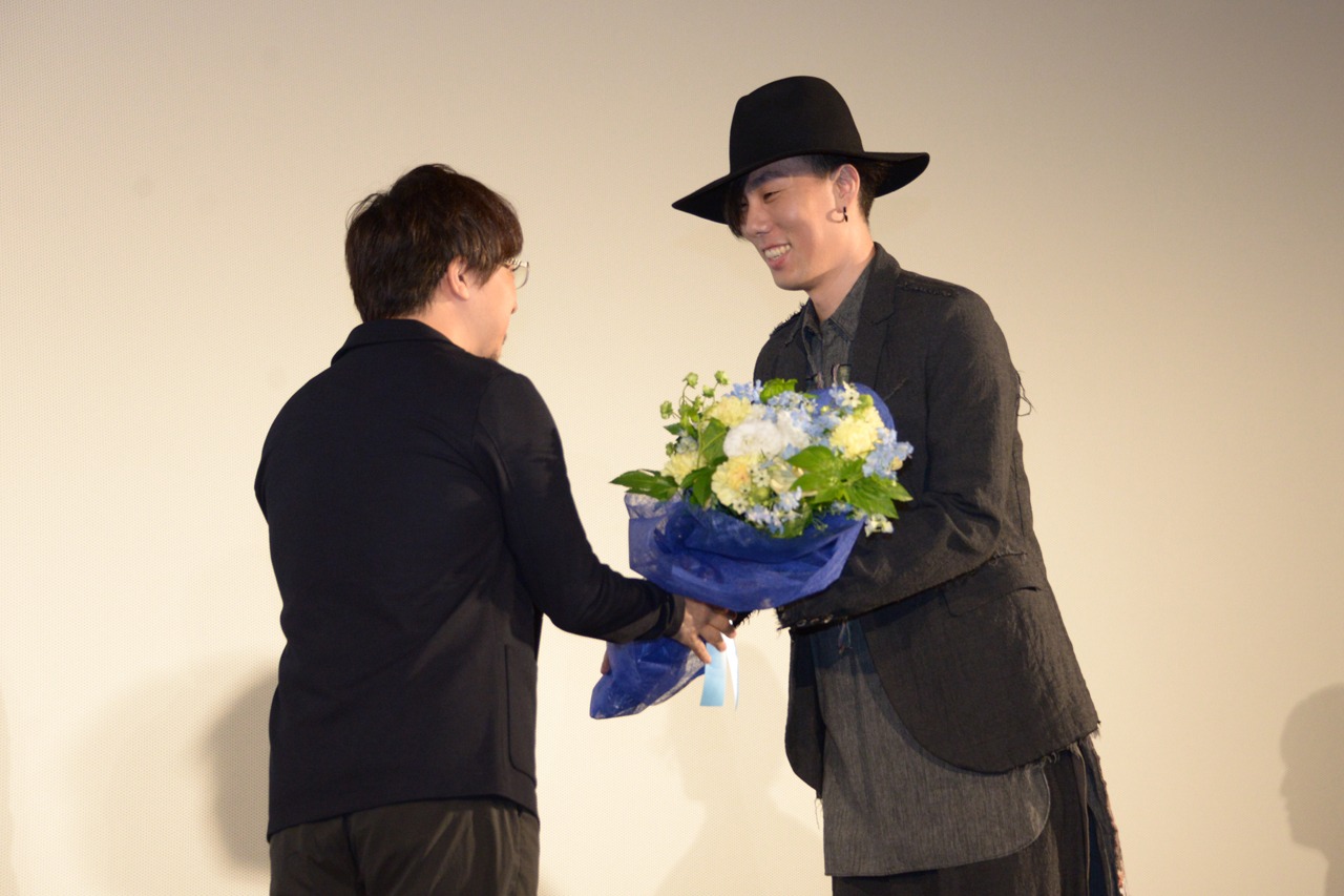 新海誠に花束を渡す野田洋次郎（RADWIMPS）。