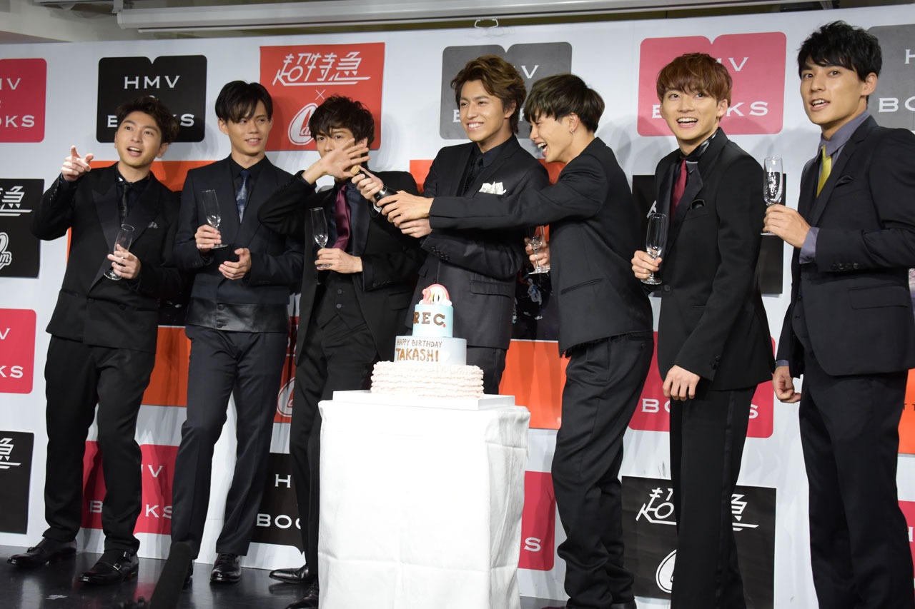 シャンパンの栓抜きに挑戦するタカシ（中央）。