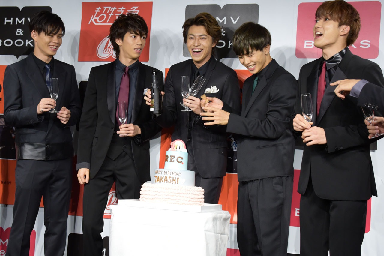 栓を抜いてしまい、苦笑いを浮かべるタクヤ（右から2番目）と、ツッコミを入れるメンバー。