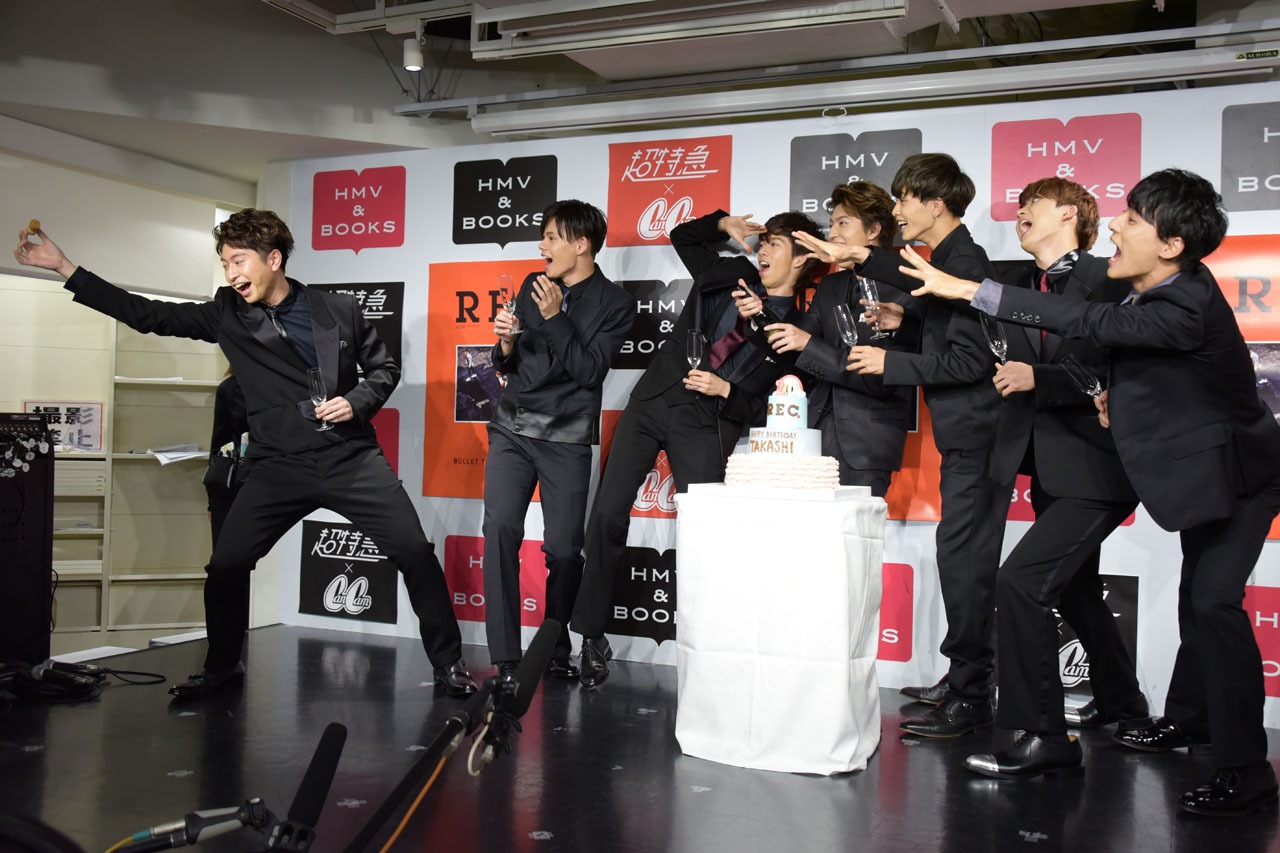 タカシ（中央）がシャンパンの栓を抜いたかのように偽装する超特急。