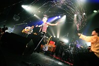 夏目創太（G, Cho）に向けてクラッカーを発射する下川リオ（Vo, G）。（撮影：新倉映見）