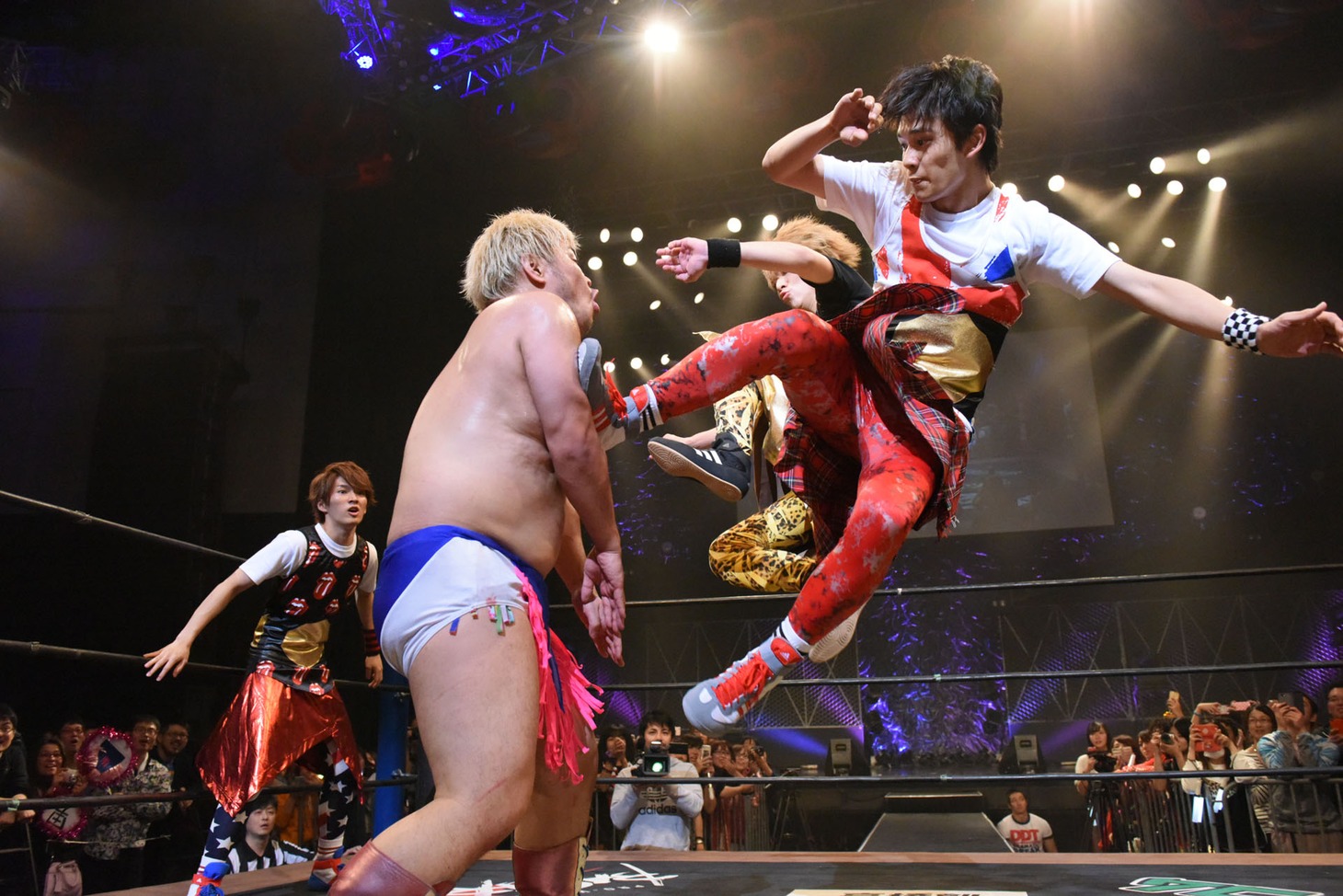 男色ディーノ（左）にダブルのドロップキックを仕掛けるDISH//のTAKUMI（右手前）とRYUJI（右奥）。（写真提供：DDTプロレスリング）