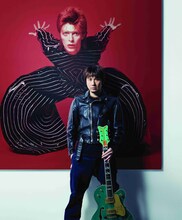 デヴィッド・ボウイの写真の前に立つ横山健。 DAVID BOWIE (c)MASAYOSHI SUKITA 1973