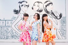 ジェイソン ブルックスが描いたイラストの前に立つPerfume。
