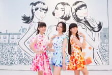 ジェイソン ブルックスが描いたイラストの前に立つPerfume。
