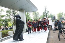 黒づくめの男（左）をいぶかしげに見つめるSUPER★DRAGON。（撮影：笹森健一）