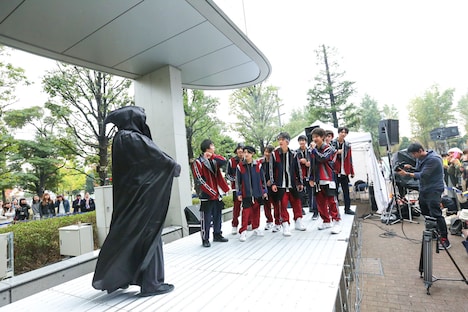 黒づくめの男（左）をいぶかしげに見つめるSUPER★DRAGON。（撮影：笹森健一）