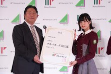 マネーパートナーズ奥山泰全代表取締役社長より「マネパカード」宣伝部所属の辞令を受け取る平手友梨奈。