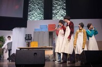 生着替えのブースに入る塩崎太智（左）と、彼を見送るメンバー。