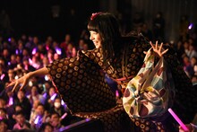 熊のぬいぐるみを客席に投げる真山りか。