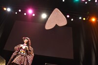 ハート型の紙飛行機を持つ真山りか。