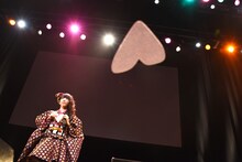 ハート型の紙飛行機を持つ真山りか。