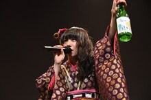 自身でラベルをデザインした酒瓶を持つ真山りか。