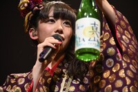 自身でラベルをデザインした酒瓶を持つ真山りか。
