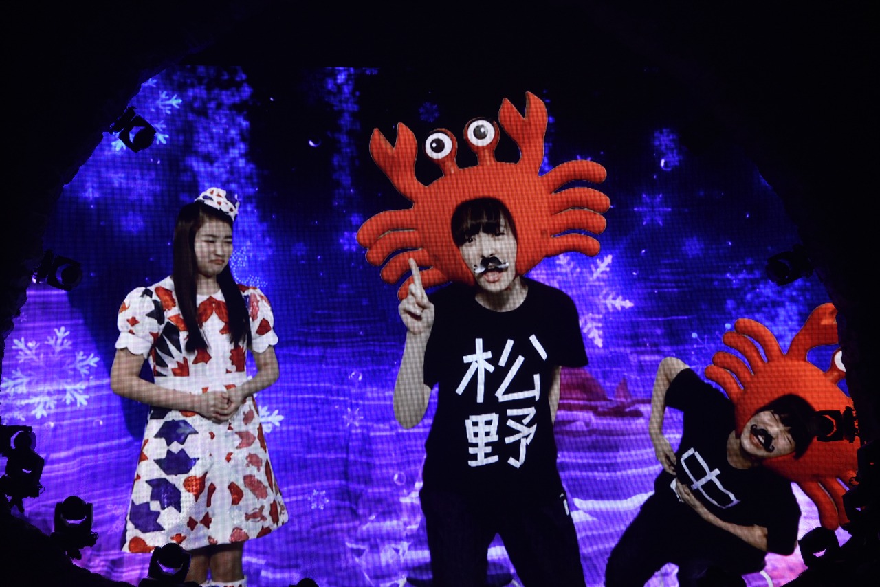 ショートコントを披露する松野莉奈（中央）と中山莉子（右）、それを見守る柏木ひなた（左）の映像。