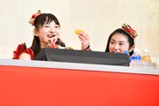 ステージ上でみかんをモリモリ食べる松野莉奈（左）。