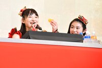 ステージ上でみかんをモリモリ食べる松野莉奈（左）。