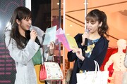“1日プレス”の一環として、2人でデザインに関わったクリアファイルをアピールする佐藤晴美と楓。