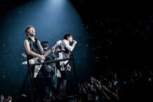 トロッコでアリーナを移動するIKE（Vo）とUZ（G, Programming）、MOMIKEN（B）。