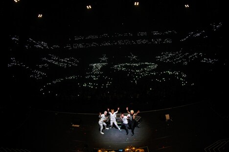 座席占いで大凶を引いた人のまばらな灯りとともに記念撮影するゴールデンボンバー。（撮影：菅沼剛弘）