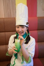 「Love＆Peace Green Nature ドリンク～メロンソーダ、バニラアイス～」を飲む日高麻鈴。