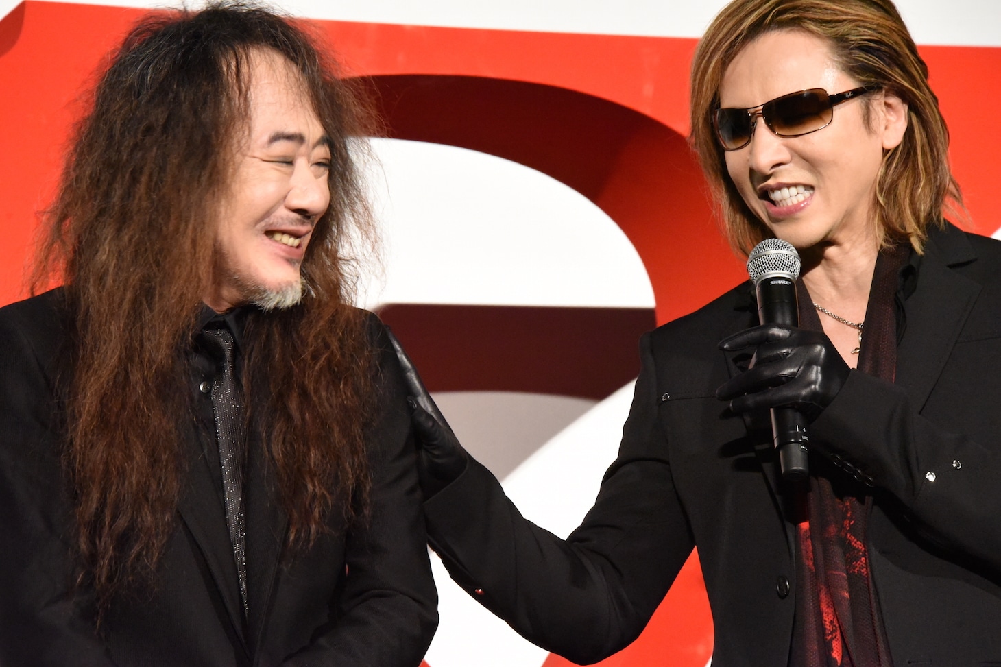 PATA（左）の肩を叩くYOSHIKI（右）。