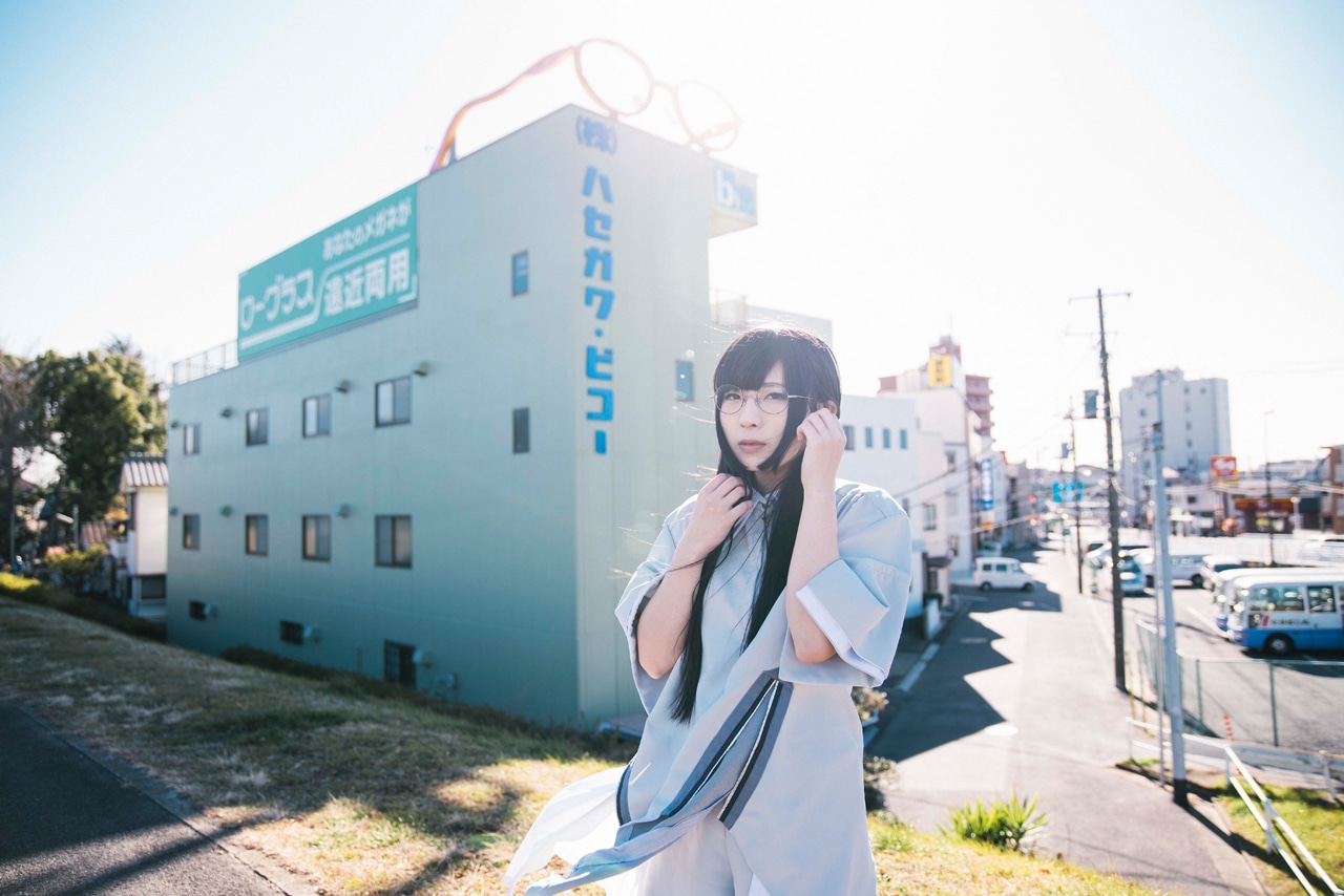 株式会社ハセガワ・ビコーの工場前に立つ和田輪（Maison book girl）。