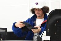 商品会議でキャップのサンプルを手にするZEN-LA-ROCK。