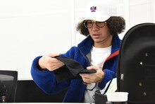 商品会議でキャップのサンプルを手にするZEN-LA-ROCK。