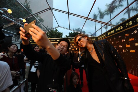 メディア関係者との記念写真に応じるYOSHIKI。