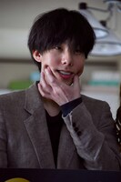 カメラマンに笑顔を求められ、顔をほぐす野田洋次郎。